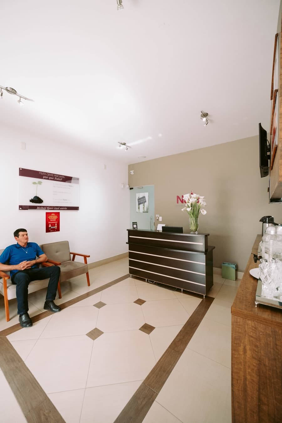 Recepção da clínica, com poltronas e balcão de atendimento